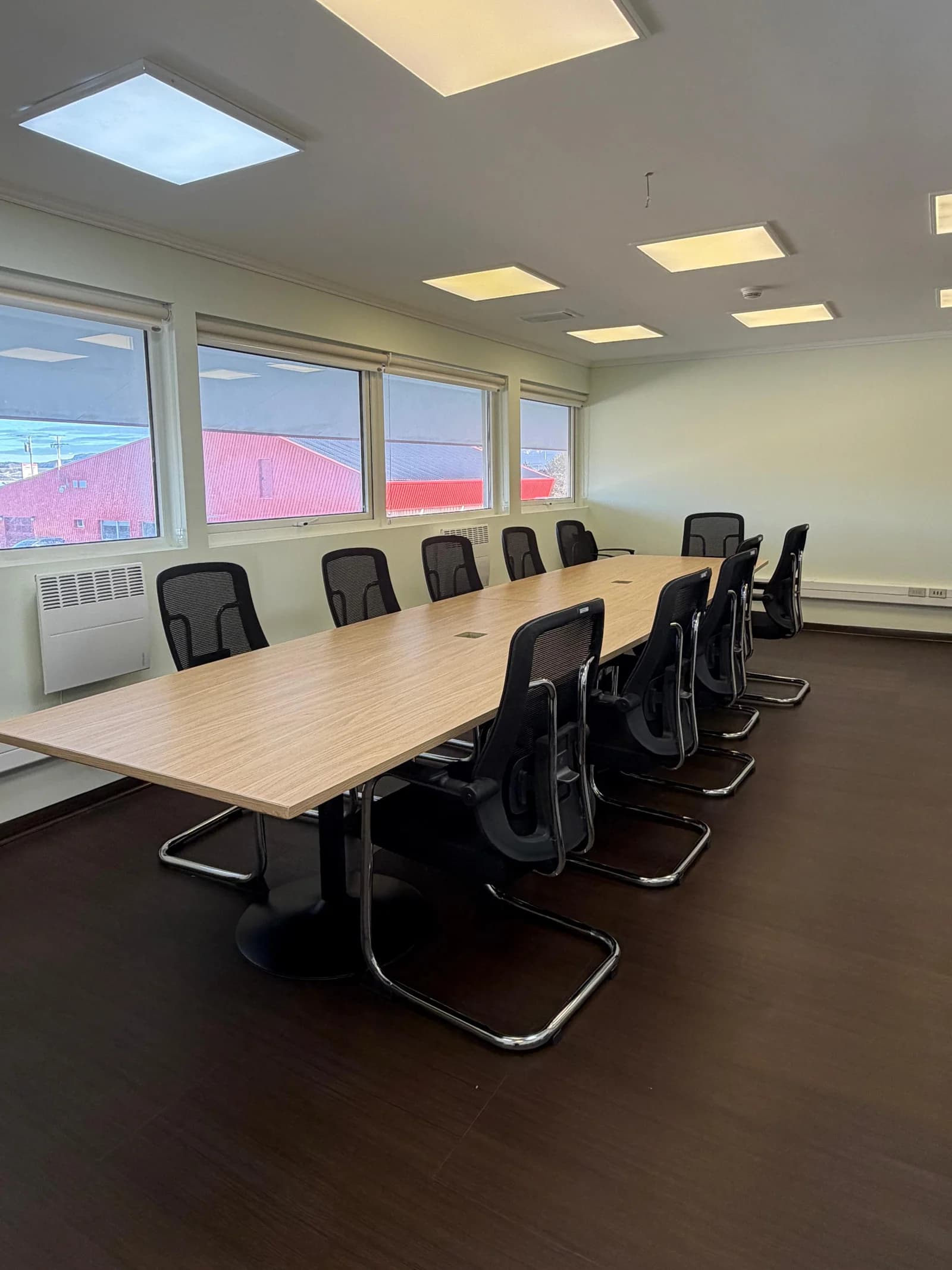 Sala de reuniones DGAC remodelada, con mesa de trabajo, ventanales e iluminación de cielo